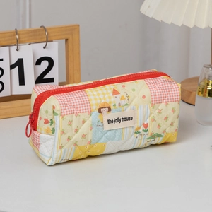 Detailed close-up of quilted floral pencil case with zipper and the jolly house label