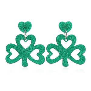 Close-up of green glitter shamrock earrings with hollow heart accents and silver links