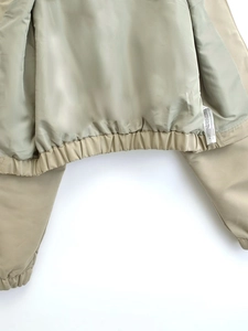 Detail of light beige jacket lining with drawstring hem and quality stitching seams