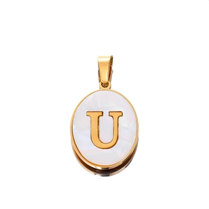 Macro detail of oval pendant with letter U on white mother-of-pearl and gold finish