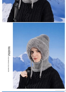 Detail of grey cable knit winter hat with thick faux fur lining and pompom accent