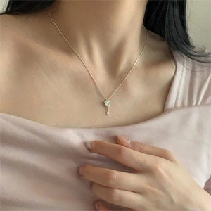 Detail of 925 sterling silver heart key necklace with sparkling zircon on model