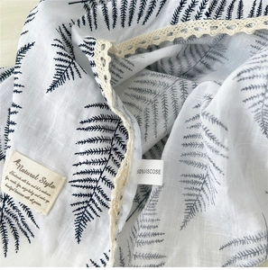 Detail of floral viscose scarf fabric with white lace edge and natural leaf print