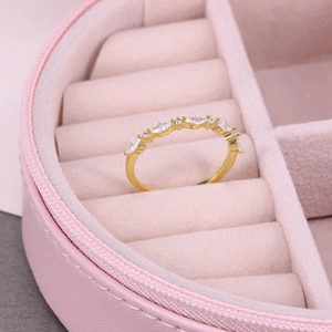 Detailed close-up of a luxury gold ring with sparkling marquise stones in a pink jewelry case