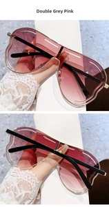 Détail de lunettes de soleil sans monture avec verres dégradés gris-rose et bords ondulés