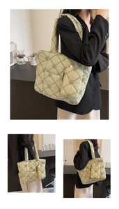 Detail view of large light green quilted tote bag with floral embroidery and small pouch