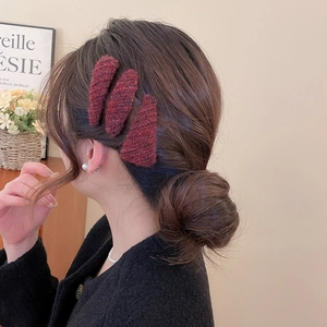 Close-up of wine red tweed hair clip set for women with cozy autumn vibes background