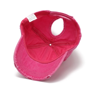 Detail of internal lining and ponytail hole on washed rose red cotton baseball cap