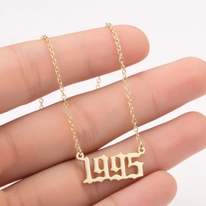 Detail of 1995 birth year pendant in gold plating held to show fine chain texture