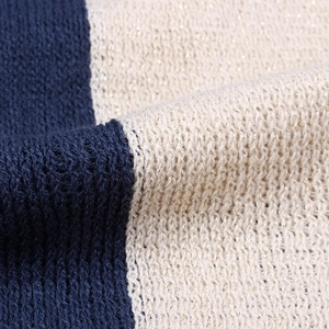 Macro shot of knitted fabric texture with navy blue and metallic beige yarn stripes