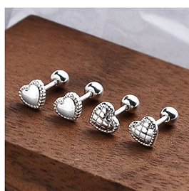 Macro view of S925 sterling silver heart earrings with screw back design on wood