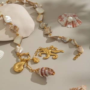 Detail of ocean-themed necklace with golden octopus, seashells, and irregular pearls