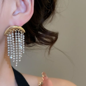 Gros plan de boucles d'oreilles lune à franges scintillantes portées par un mannequin