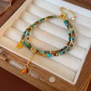 Bracelet double couche en perles turquoise avec breloque H dorée et style ethnique