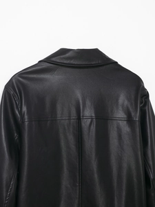 Detail view of the high-quality black faux leather jacket back seam and collar texture
