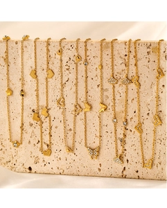 Detail of gold butterfly and heart pendants with micro-inlays on fine link chains