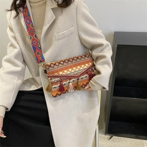 Ethnic bohemian crossbody bag with orange fringes and colorful woven geometric strap