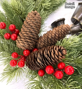 Detailed close-up of Christmas wreath with brown pine cones, red berries and green pine needles