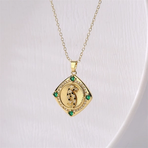 Gold snake pendant necklace featuring emerald green stones and zircon animal charm