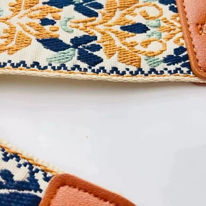 Detail of 5cm ethnic wide guitar strap with floral pattern and brown leather ends