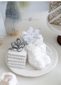 Close-up of elegant white glitter gift box and plush boot ornaments on a plate