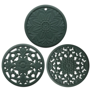 Detail of dark green hollow floral silicone heat resistant pads with relief patterns