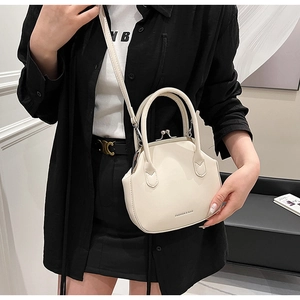Detail of cream white vintage kiss-lock handbag with dual handles and slim shoulder strap