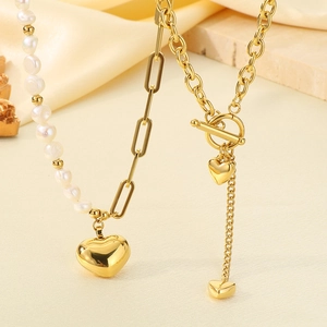 Detail von Perlenhalskette und goldener Gliederkette mit Herzanhängern auf Seidentuch