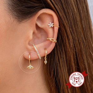 Macro view of gold-plated eye-shaped pendant earring set with sparkling zircons