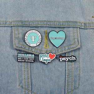 Psychology enamel pin set with blue hearts and lettering on a denim jacket pocket