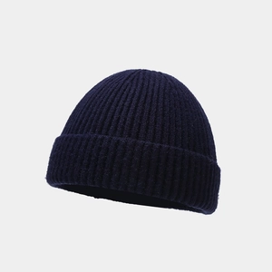 Close-up of deep navy blue knit texture and fine craftsmanship on the skull cap