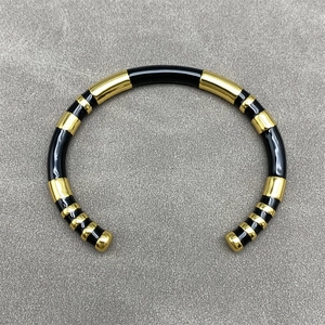 Minimalist C-shaped open bangle featuring stylish black and gold striped metal design