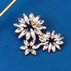 Elegant gold hair clip with crystal flowers and leaves on a dark blue background