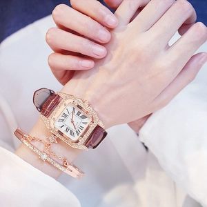 Square rose gold watch with brown leather strap and matching star charm bracelet on wrist