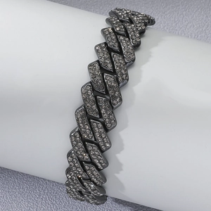 Detail of grey diamond-encrusted Cuban link chain on white display stand in studio lighting