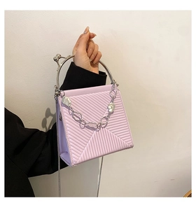 Detail of light purple handbag featuring geometric embossing and silver metal ring handle