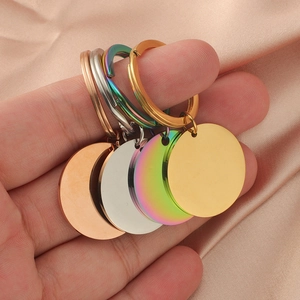 Close-up of circular stainless steel keychains in gold, rose gold, silver, and rainbow colors