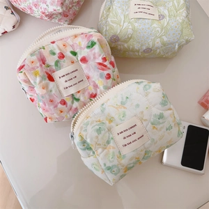 Close-up of quilted floral cotton makeup bags in pink, purple and green with zippers