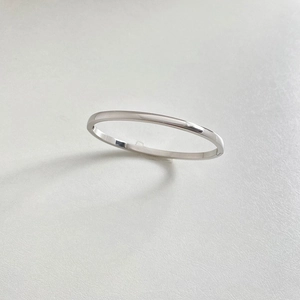 Polished silver stainless steel bangle with minimalist sleek finish and side clasp detail