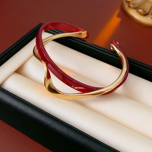 Close-up of dual-layer gold plated bangle with red enamel finish on jewelry box