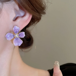 French style purple enamel flower earring with pearl center shown on a female model