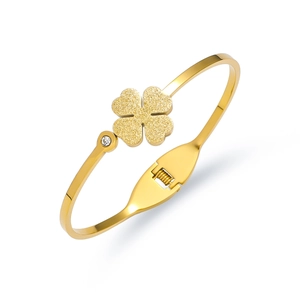 Detail view of gold titanium steel bangle with frosted clover and zircon accent