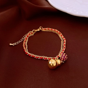 Detail of 18k gold plated double-layer chain bracelet with red thread and cat eye stone