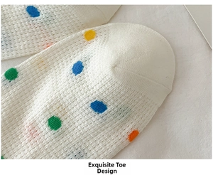 Detail of breathable white mesh socks with colorful polka dots and fine toe stitching