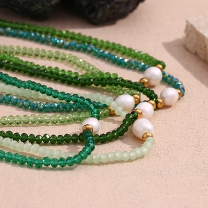 Detailed close-up of mint green crystal beads and large pearls on a bohemian necklace
