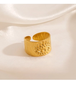 Vue détaillée d'une bague dorée œil protecteur avec texture en métal brossé sur soie