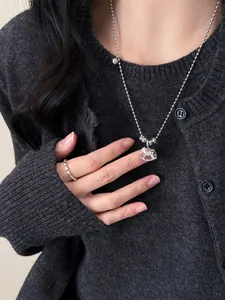 Detail of silver rocking horse pendant with rhinestones and matching beaded ring on model