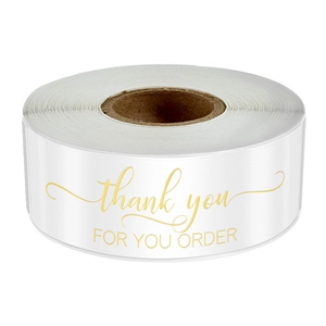 Macro detail of round white adhesive labels with elegant gold foil thank you text