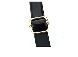 Detail of glossy black leather shoulder strap with golden metal buckle and stitching