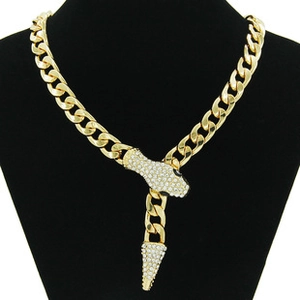 Detail of gold Cuban chain necklace with sparkling zircon snake head and tail pendant